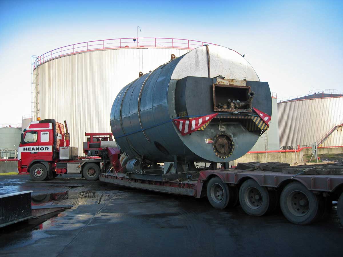 Partially dismantled boiler loaded onto large transport vehicle